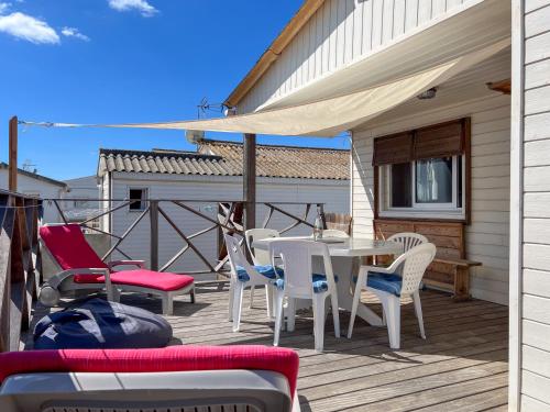 a patio with a table and chairs on a deck at L'authentique chalet en bois sur pilotis in Gruissan