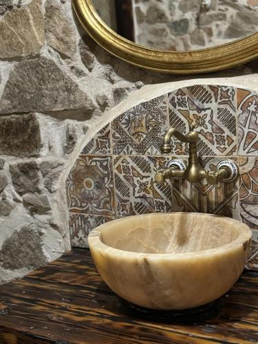 a bathroom sink with a faucet on a stone wall at Czerwony Dworek 8 - Agroturystyka Karkonosze in Mysłakowice