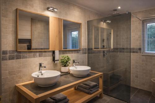 a bathroom with two sinks and a shower at Valentina Lodge in Durbuy