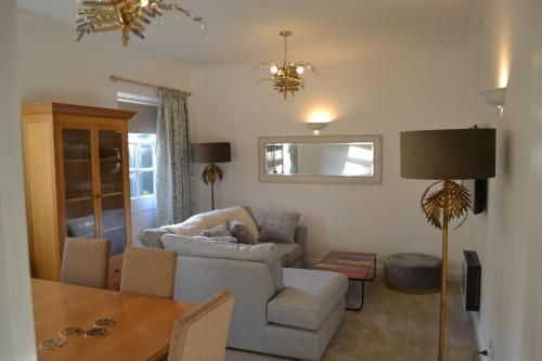 a living room with a couch and a table at Frinton Escapes - The Cottage in Frinton-on-Sea