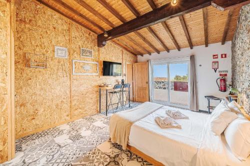 a bedroom with a bed and a large window at Villas de Cintra in Sintra