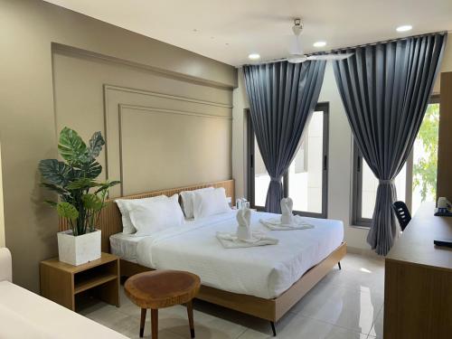 a bedroom with a large bed with blue curtains at V Club in Bhuj