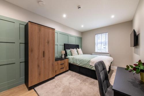 a bedroom with a bed and a large wooden cabinet at Gillingham Luxury, LNG GRAIN, Workers, Parking, Flexible Weekly Deals in Gillingham
