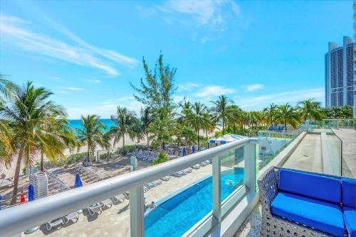 a balcony with a view of a pool and the beach at Marenas Resort Beachfront Condo with Direct Access in Sunny Isles Beach