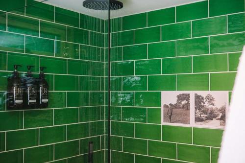 a green tiled bathroom with pictures on the wall at Mertrick in Forest Mill