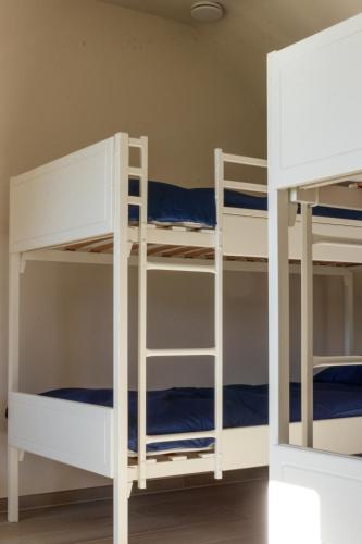 two bunk beds in a room with blue sheets at Vakantiewoning Kastijd Kortessem - Haspengouw in Kortessem