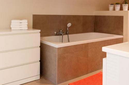 a bathroom with a bath tub in a room at Vakantiewoning Kastijd Kortessem - Haspengouw in Kortessem