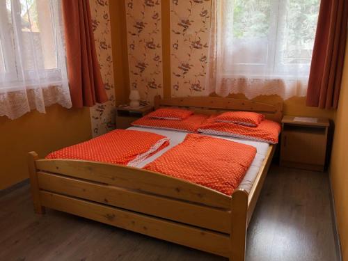 a bedroom with two beds with red comforters at Árpád Vendégház in Hajdúszoboszló