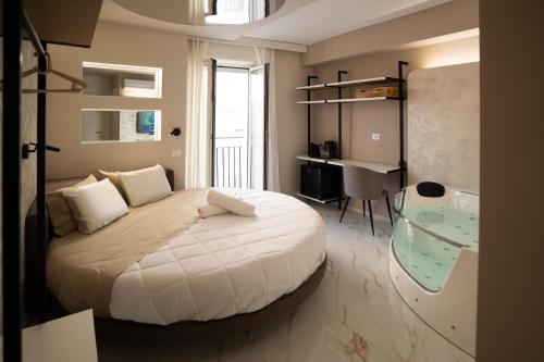 a bedroom with a large bed with a desk and a desk at Elysium suites & Spa in Barletta