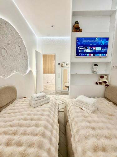 a bedroom with two beds and a flat screen tv at VILLA PIKADI BY THE Baltic Sea in Palanga