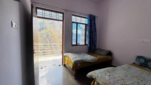 a room with two beds and a large window at Hotel Himalayan View Kedarnath in Phata