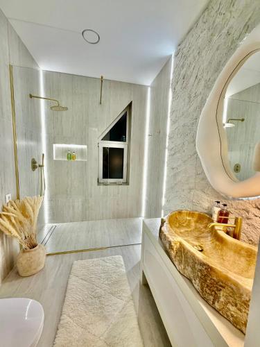 a bathroom with a large sink and a large mirror at VILLA PIKADI BY THE Baltic Sea in Palanga