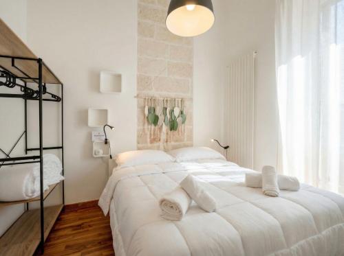 a white bedroom with two beds and a large window at Terrazza San Martino Private Terrace Stay in Monopoli