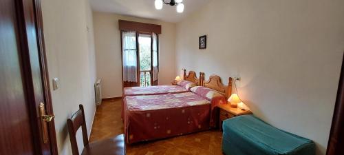 a bedroom with a bed and a table and a chair at Apartamentos Rurales Pernús in Colunga