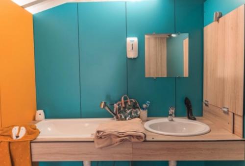 a bathroom with a tub and a sink at Camping la Peiriere - Évasion en Dôme in Tuchan