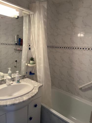 a bathroom with a sink and a tub and a shower at Appartement Cap D'Agde in Cap d'Agde