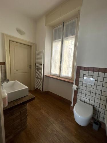 a bathroom with a white toilet and a sink at Casa La Torretta in Ceva