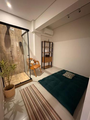 a bedroom with a green bed and a chair at Solua Hostel in Santos