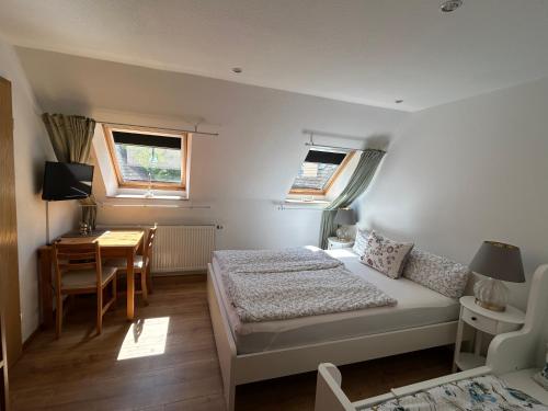 a bedroom with a bed and a table and a desk at Ferienzimmer Teiselsmühle Gehren Heideblick in Heideblick