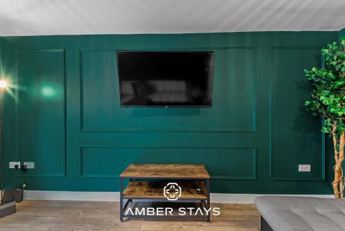a green wall with a table in a living room at Spacious 5 Bed House in Reading by Amber Stays, Perfect for Business & Contractors, Sleeps 12 in Reading