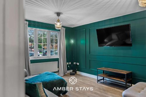 a living room with green walls and a tv at Spacious 5 Bed House in Reading by Amber Stays, Perfect for Business & Contractors, Sleeps 12 in Reading
