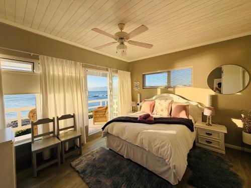 a bedroom with a bed and a ceiling fan at La Melamire On the Rocks Bed & Breakfast in Gansbaai