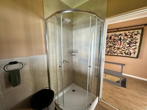 a shower with a glass door in a bathroom at Wilderness Escape with breathtaking Views in Wildernis