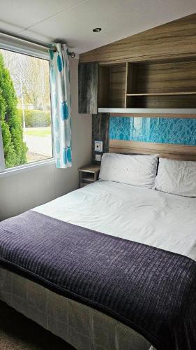 a bedroom with a large bed and a window at Sunrise Holidays Skegness - Pearl in Skegness
