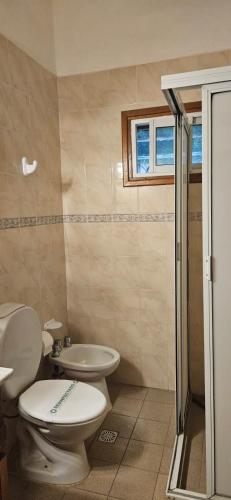 a bathroom with a toilet and a sink and a shower at Hotel Riviera in Villa Gesell