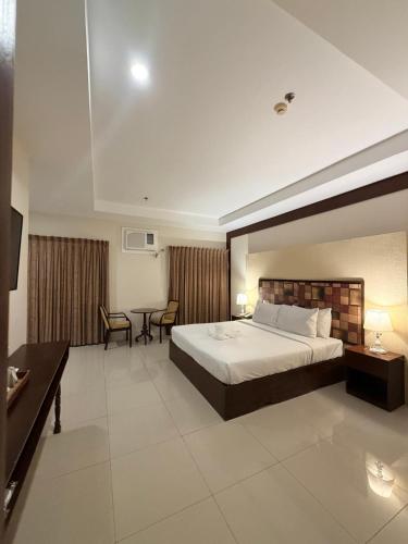 a hotel room with a large bed and a desk at Sierra Hotel in Dumaguete
