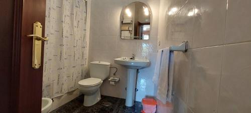 a small bathroom with a toilet and a sink at APARTAMENTOS RURALES PERNÚS in Colunga