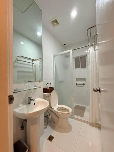 a bathroom with a toilet and a sink and a shower at Sierra Hotel in Dumaguete