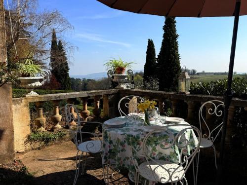 a table with chairs and an umbrella on a patio at Domaine de Montclair in Pommiers