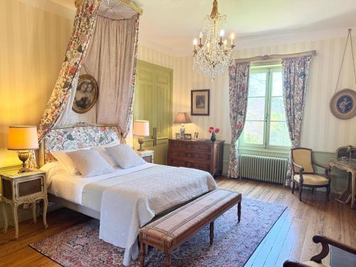 a bedroom with a large bed and a chandelier at Domaine de Montclair in Pommiers