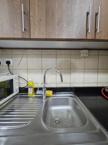 a kitchen counter with a sink and a microwave at Ajman Beach View AIO4OO7 in Ajman 