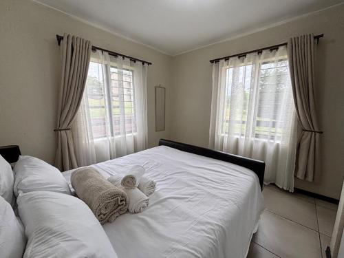 a bedroom with a white bed with towels on it at Nestled sanctuary in Northriding