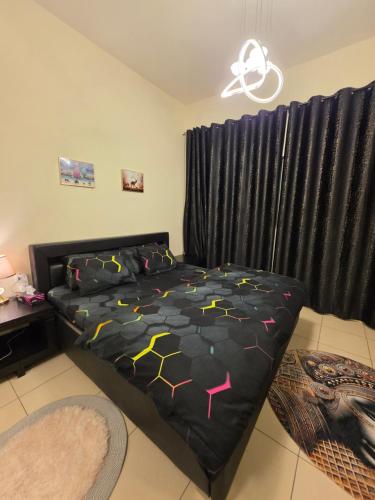 a bedroom with a bed with a black comforter at Ajman Beach View AIO4OO7 in Ajman 