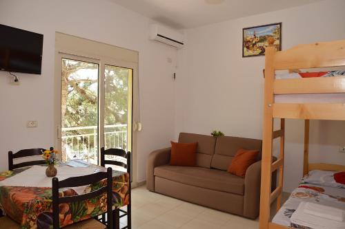 a living room with a bunk bed and a couch at Hotel Gonaj in Velipojë