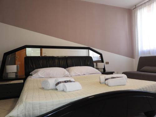 a bedroom with a large bed with two towels on it at Rosario House in Comacchio