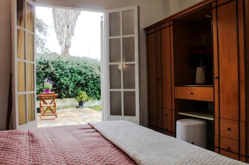 a bedroom with a bed and a large window at Spiros House in Roda
