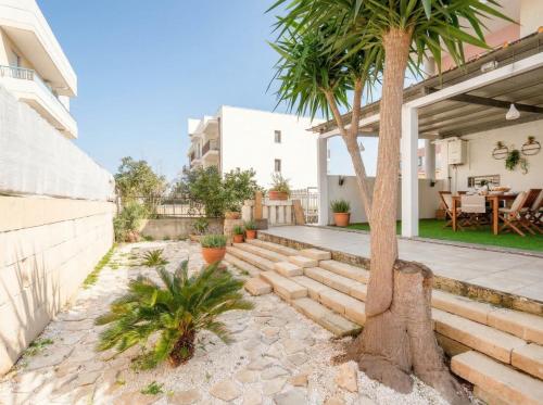 a patio with a palm tree and a house at CarmenLeo-Central Accommodation with Patio in Polignano a Mare