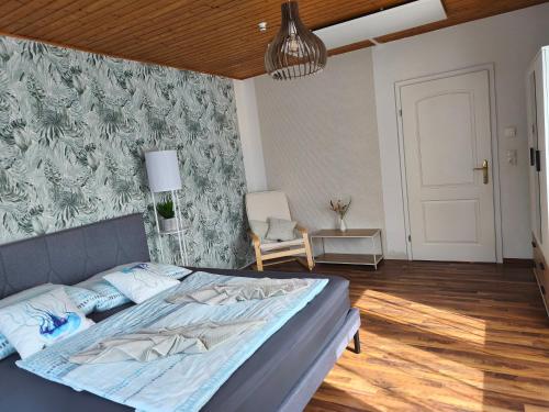 a bedroom with a bed and a chair in it at Sigi Apartment in Barnbach