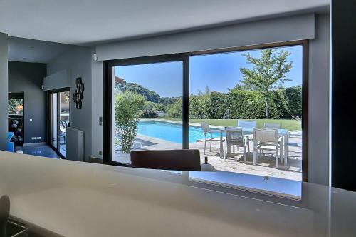 a kitchen with a view of a pool from a house at Villa d'Exception 330m Piscine 12x6 in Fontaines-Saint-Martin