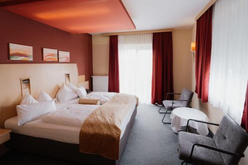 a hotel room with a bed and two chairs at Landliebe Resort Fürstenfeld By Belvilla in Söchau