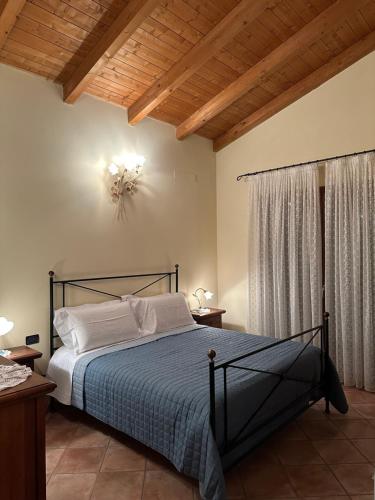 a bedroom with a bed in a room with a ceiling at B&B La Collina degli Ulivi in Zola Predosa