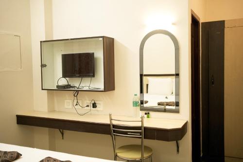 a bathroom with a sink and a mirror at Hotel BMR Stay in Pollāchi