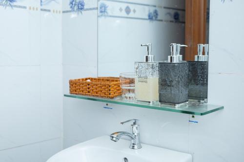 a bathroom with a sink and a mirror and a shelf at Khách sạn Cozy Home 2 in Can Tho