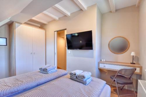 two beds in a room with a tv and a mirror at Ferienhaus Boddenlust 24 Feriendorf Klein Stresow Rügen by ruyastay in Putbus