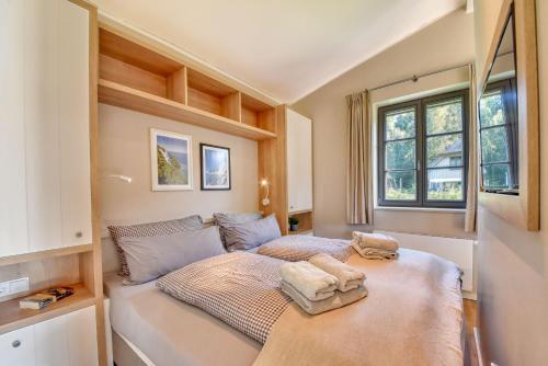 a small bedroom with a bed and a window at Ferienhaus Strandbude Feriendorf 32 Klein Stresow Rügen by ruyastay in Putbus