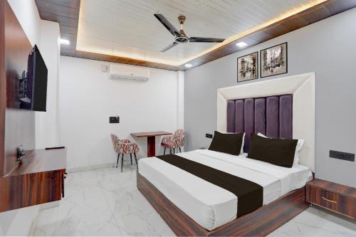 a bedroom with a bed and a table and a tv at Townhouse Tuessday Suites Nearst Mr Bhatura Bala Sector 122 in Noida